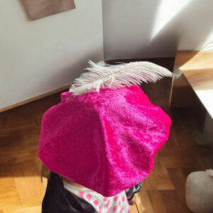 Fuchsia velours Pietenmuts met witte of paarse veer, geschikt voor kinderen van 1 tot 9 jaar.